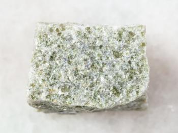 macro shooting of natural mineral rock specimen - raw quartz-mica schist stone on white marble background