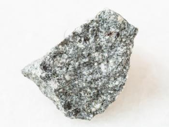 macro shooting of natural mineral rock specimen - raw Diorite stone on white marble background