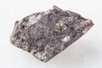 macro shooting of natural mineral rock specimen - raw porphyritic Basalt stone on white marble background