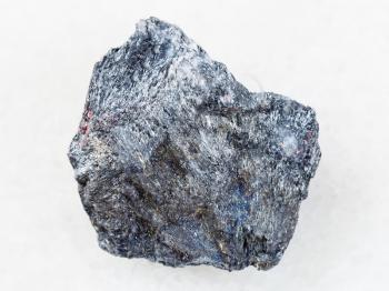macro shooting of natural mineral rock specimen - antimony ore (Stibnite) stone on white marble background from Ukraine