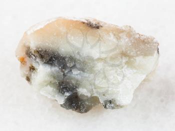 macro shooting of natural mineral rock specimen - rough talc stone on white marble background from Irkutsk region