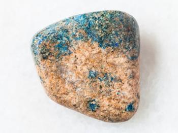 macro shooting of natural mineral rock specimen - tumbled azurite stone on white marble background from Kazakhstan
