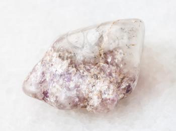 macro shooting of natural mineral rock specimen - pink Tourmaline crystas in Lepidolite mica in polished quartz stone on white marble background from Kalba mine, Kazakhstan