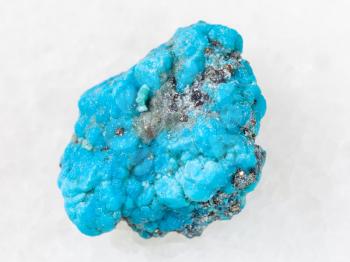 macro shooting of natural mineral rock specimen - blue Turquoise gemstone on white marble background from Mexico