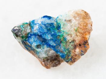 macro shooting of natural mineral rock specimen - tennantite crystal, green Tyrolite and blue Azurite on quartz gemstone on white marble background from Ural Mountains, Russia