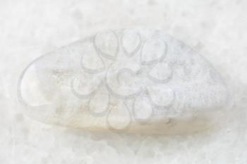 macro shooting of natural mineral rock specimen - white moonstone (adularia) gemstone on white marble background