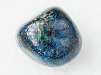 macro shooting of natural mineral rock specimen - tumbled Azurite gemstone on white marble background