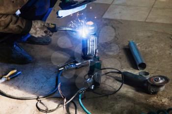 repairing of corrugation muffler of exhaust system in car workshop - welder welds the pipe on corrugation muffler by argon welding