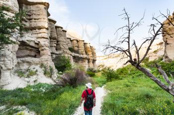 Travel to Turkey - tourist walks in ravine near Goreme town in Cappadocia in spring