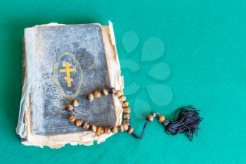 worry beads and old orthodox church book on green baize table