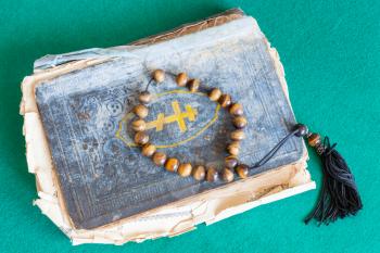 worry beads above old orthodox psalm book on green baize table