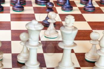 view from white side of first chess pawn moves close up on chessboard