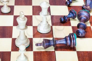 business concept - falling black chess pieces and wining white chessmen