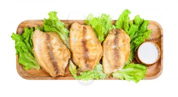 top view of fried ocean perch fillet on wooden tray isolated on white background