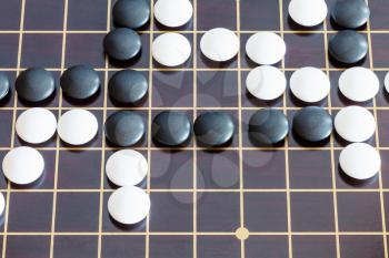 top view of playing in Go game on wooden board