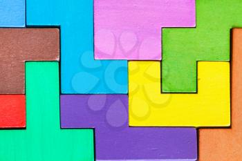 surface of assembled puzzle from colored wooden pentominoes and blocks