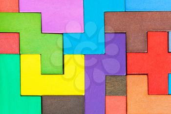 background from assembled puzzle from colored wooden pentominoes and blocks