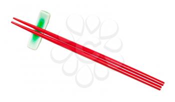 top view of red painted wooden chopsticks served on chopstick rest isolated on white background