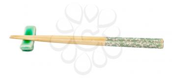 side view of decorated wooden chopsticks served on chopstick rest isolated on white background
