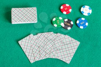 top view of card decks and casino tokens on green baize table