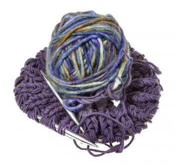 above view of ball of multi-colored yarn on knitted snood scarf isolated on white background