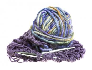 ball of multi-colored yarn and knitting needles in knitted cloth isolated on white background