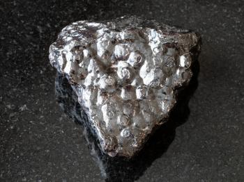 macro shooting of natural rock specimen - rough Hematite (Kidney Ore) stone on black granite background from Morocco
