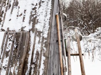 old typical tools ( ice picks and ladles) near closed well in russian village in overcast winter day in Smolensk region of Russia
