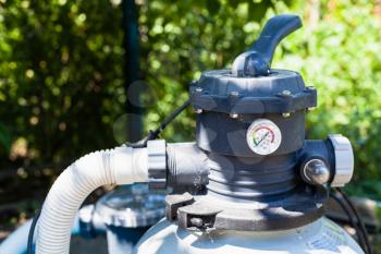 water pump of outdoor filtering system of swimming pool in summer day