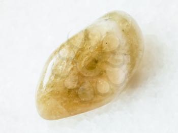 macro shooting of natural rock specimen - polished Prasiolite (green quartz , Vermarine) gemstone on white marble background from Brazil