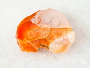 macro shooting of natural mineral - rough noble opal and fire opal gemstone on white marble from Ural Mountains
