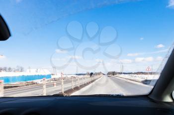 view of M1 highway (Russian route M1, Belarus Highway, European route E30) in Smolensk oblast of Russia in winter day through windscreen