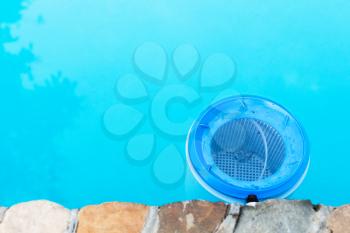 water filter at the wall of outdoor swimming pool in summer day