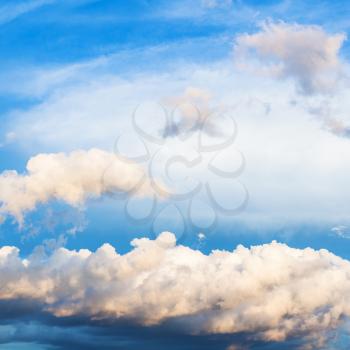 white and gray cumuli clouds in dark blue sky over Moscow in summer evening