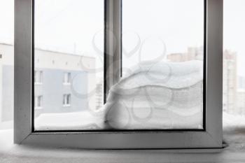 snowdrift between windowpanes of residential house in Moscow city in winter