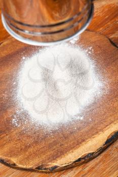 cooking of pie - flour sifting through sifter on wooden board