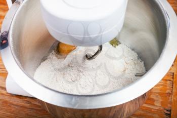 cooking of pie - kitchen processor kneads flour with egg