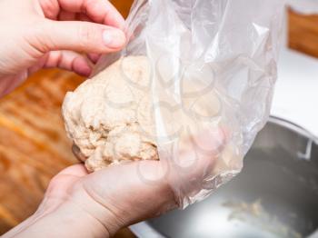 cooking of pie - hands put the ball of dough in plastic bag