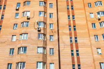 facade of urban brick multi-storey house in Moscow city on sunny summer day