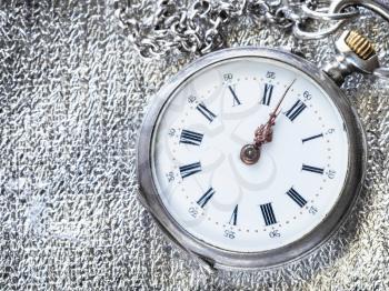 antique pocket watch on silver fabric background close up