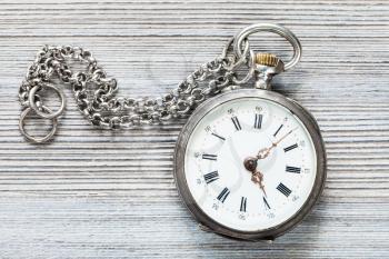 retro pocket watch with chain on gray wooden background