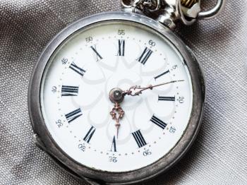 retro pocket watch on gray textile background close up