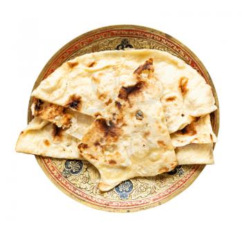 Indian cuisine - Naan flat bread baked in tandoor on brass plate isolated on white background