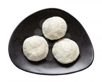 Indian cuisine - Idli Sambar steamed rice and urad bean dal dumplings on black plate isolated on white background