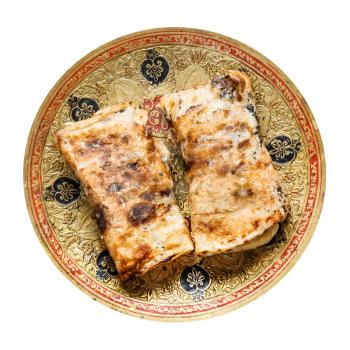 Indian cuisine - rolled Butter Naan flat bread baked in tandoor with butter on brass plate isolated on white background