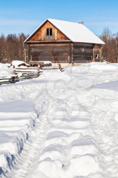 snow-covered road in russian village Kikino in Smolensk Oblast of Russia in sunny winter day