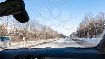 view of M1 highway (Russian route M1, Belarus Highway, European route E30) in Smolensk oblast of Russia in winter day through windshield