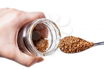 female hand keeps glass jar and spoon with freeze-dried coffee isolated on white background