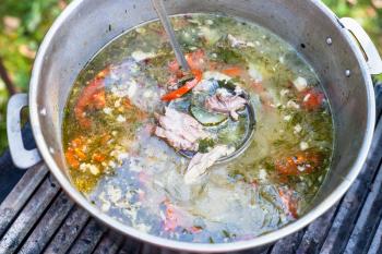 top view of pot with asian shurpa (soup from meat and large-sliced vegetables) outdoors