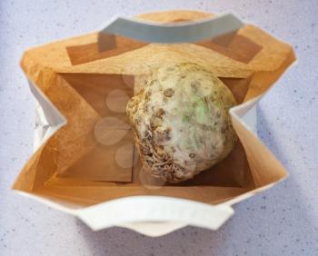 top view of celery root in a paper bag on stone board